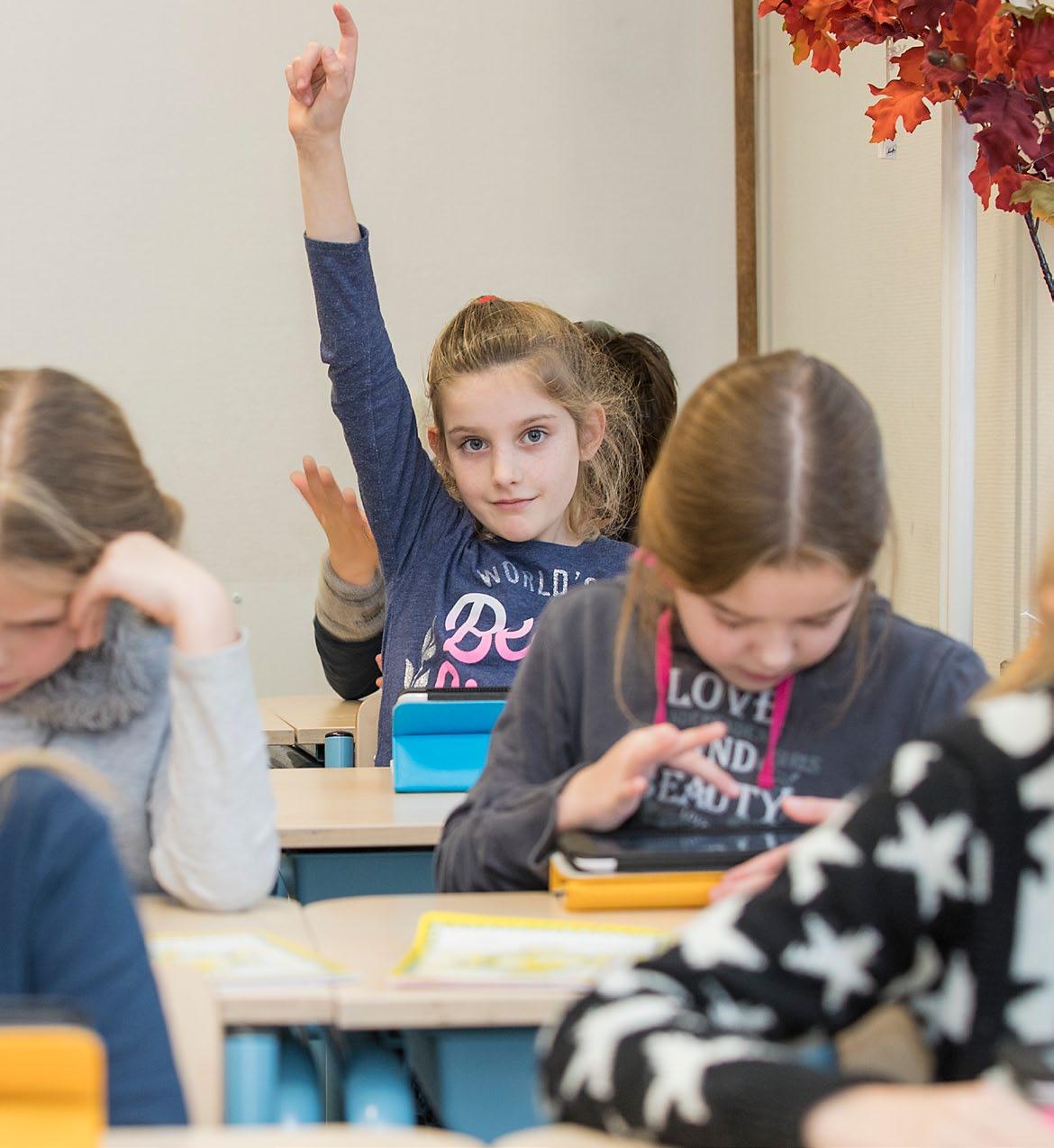 Een meisje steekt haar hand op in de klas van de Houtrustschool in Den Haag. Een meisje steekt haar hand op in de klas van de Houtrustschool in Den Haag.