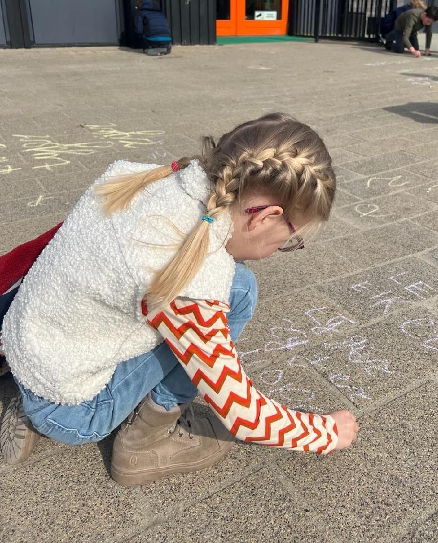Een meisje tekent met krijt op het schoolplein van 'T Paalhoofd' in Zoutelande. Een meisje tekent met krijt op het schoolplein van 'T Paalhoofd' in Zoutelande.