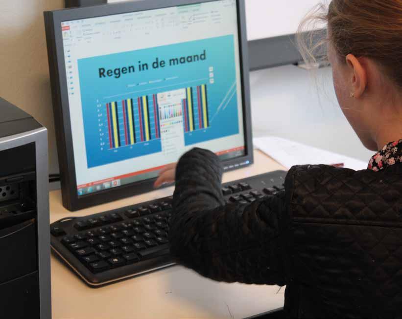 Een meisje werkt aan een computer met een presentatie over regen in de maand op de Mariaschool in Hoorn. Een meisje werkt aan een computer met een presentatie over regen in de maand op de Mariaschool in Hoorn.