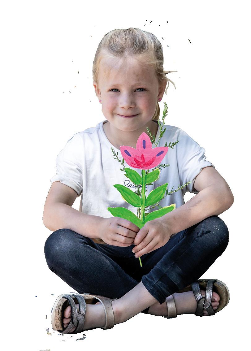Een meisje zit op de grond met een zelfgemaakte bloem in haar handen, gemaakt op Kindplein 't Centrum in Uden. Een meisje zit op de grond met een zelfgemaakte bloem in haar handen, gemaakt op Kindplein 't Centrum in Uden.