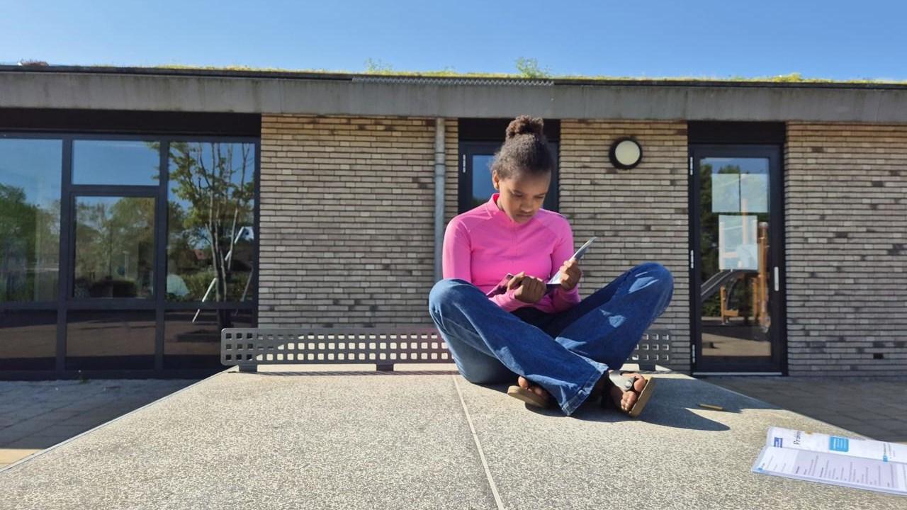 Een meisje zit op het schoolplein van OBS De SamenSprong in Steenwijk en is bezig met lezen. Een meisje zit op het schoolplein van OBS De SamenSprong in Steenwijk en is bezig met lezen.