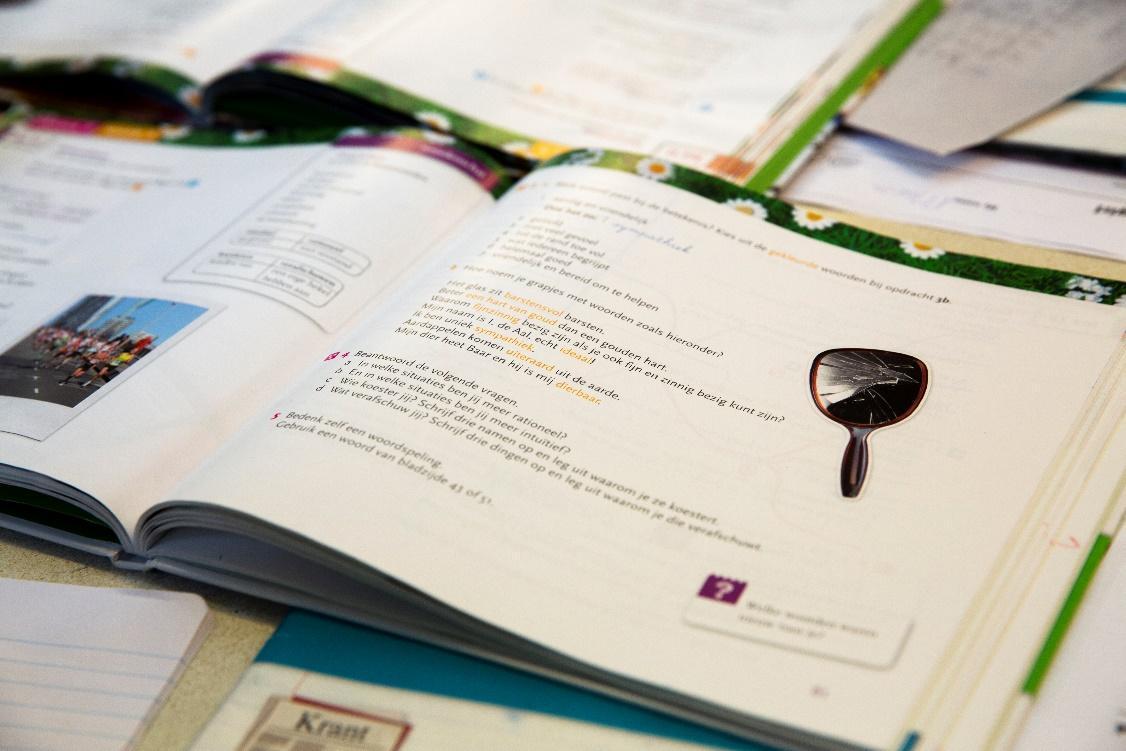 Een open boek met schoolopdrachten van Basisschool De Uilenburcht in Driebergen-Rijsenburg, met een kapotte spiegel op de pagina. Een open boek met schoolopdrachten van Basisschool De Uilenburcht in Driebergen-Rijsenburg, met een kapotte spiegel op de pagina.