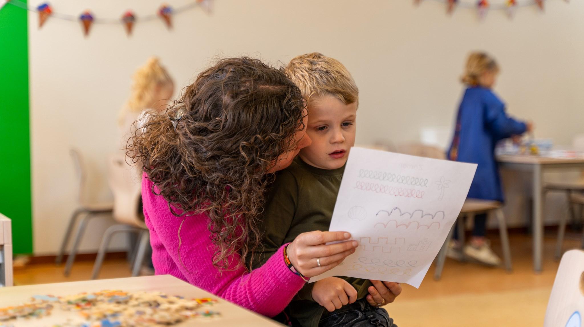 Een ouder en een kind bekijken samen een tekening op Basisschool Groen van Prinsterer in Kampen. Een ouder en een kind bekijken samen een tekening op Basisschool Groen van Prinsterer in Kampen.