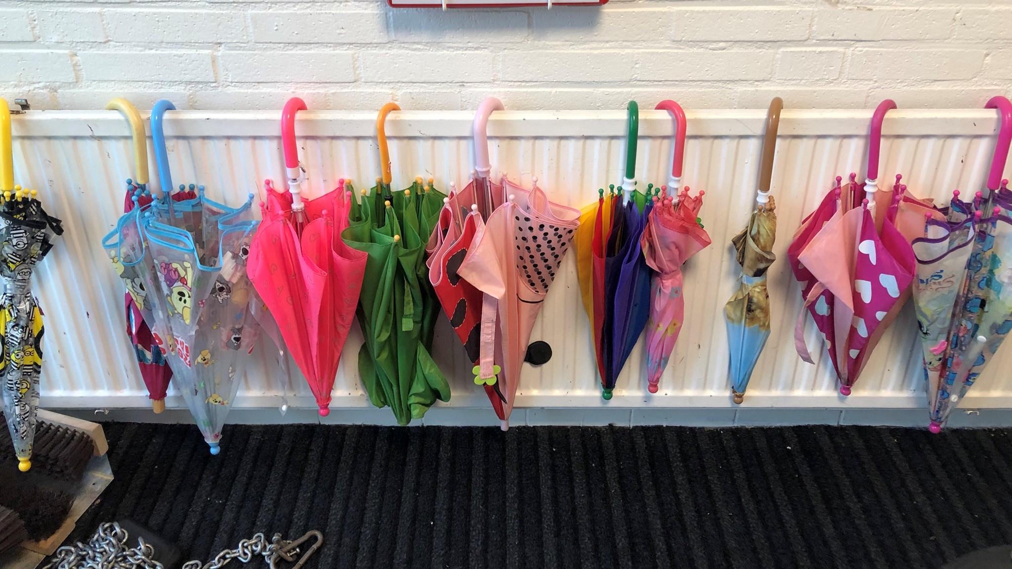 Een rij kleurrijke paraplu's hangt aan de muur in Kindcentrum Willibrord in Heiloo. Een rij kleurrijke paraplu's hangt aan de muur in Kindcentrum Willibrord in Heiloo.