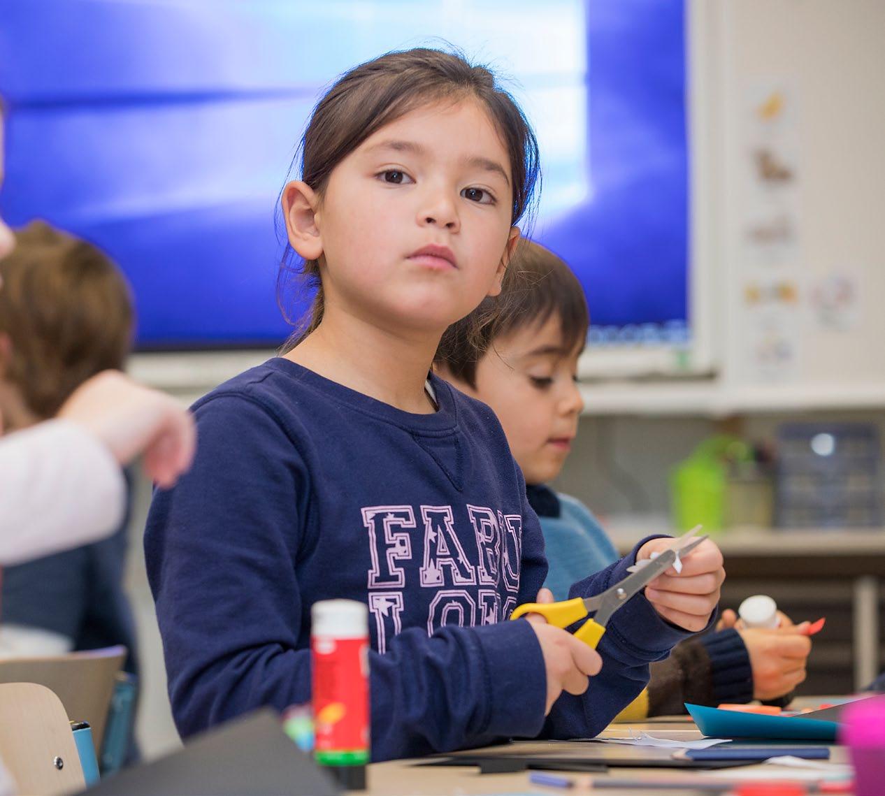 Een student aan de Houtrustschool in Den Haag knipt met een schaar tijdens een creatieve les. Een student aan de Houtrustschool in Den Haag knipt met een schaar tijdens een creatieve les.