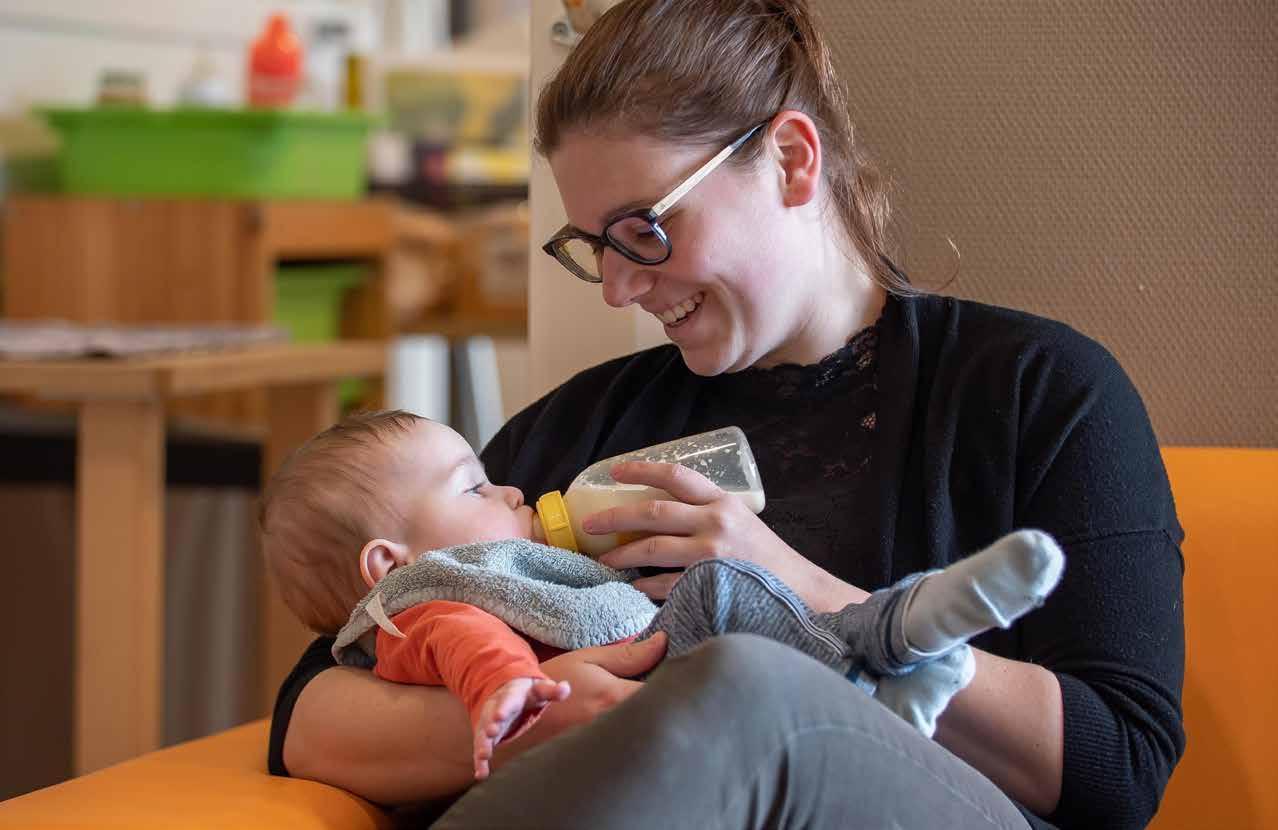 Een verzorgster geeft liefdevol een flesje melk aan een baby in ATO-kindcentrum De Hoven in Rosmalen. Een verzorgster geeft liefdevol een flesje melk aan een baby in ATO-kindcentrum De Hoven in Rosmalen.