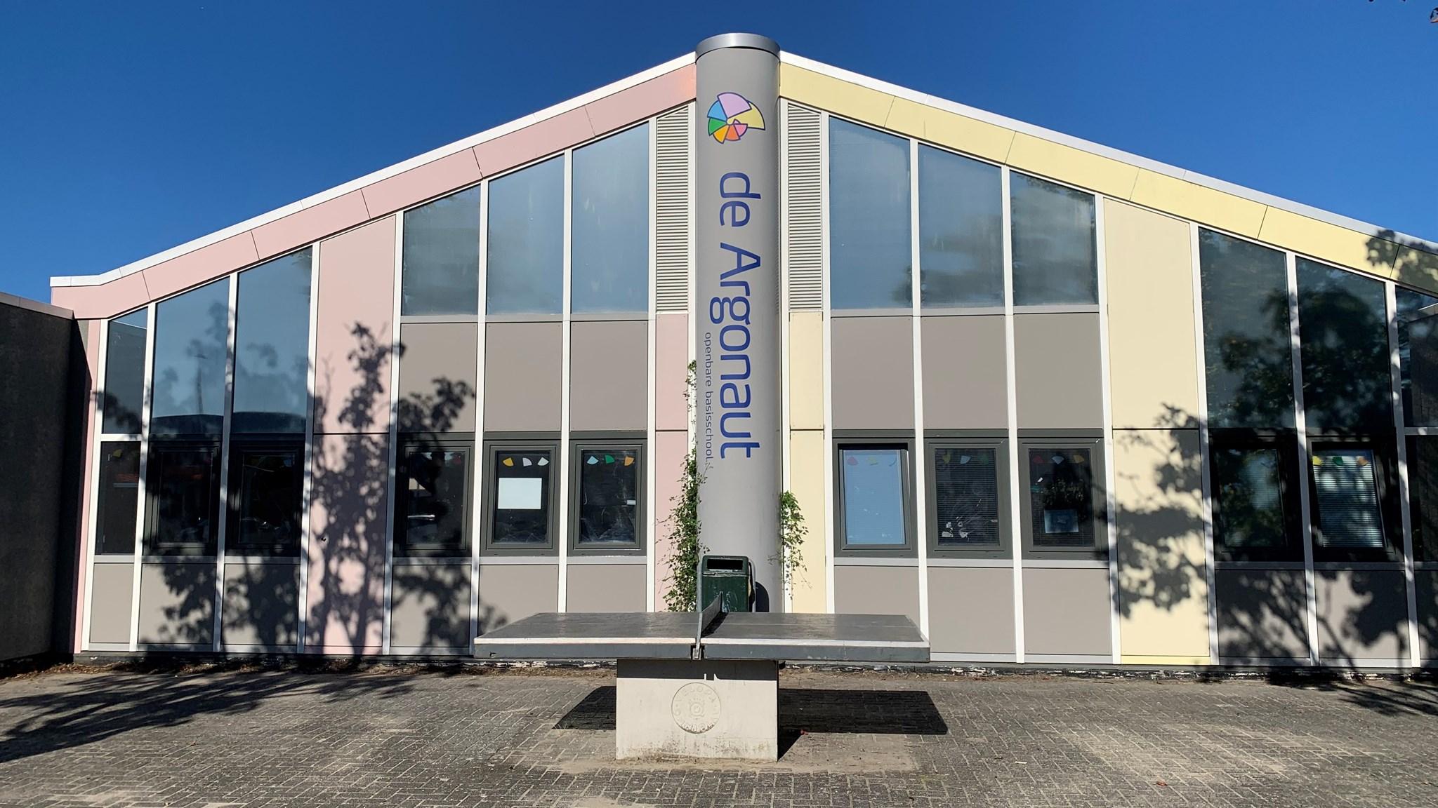 Foto van de voorgevel van Basisschool De Argonaut in Almere, met een zonnige lucht en een tafeltennistafel op het schoolplein. Foto van de voorgevel van Basisschool De Argonaut in Almere, met een zonnige lucht en een tafeltennistafel op het schoolplein.