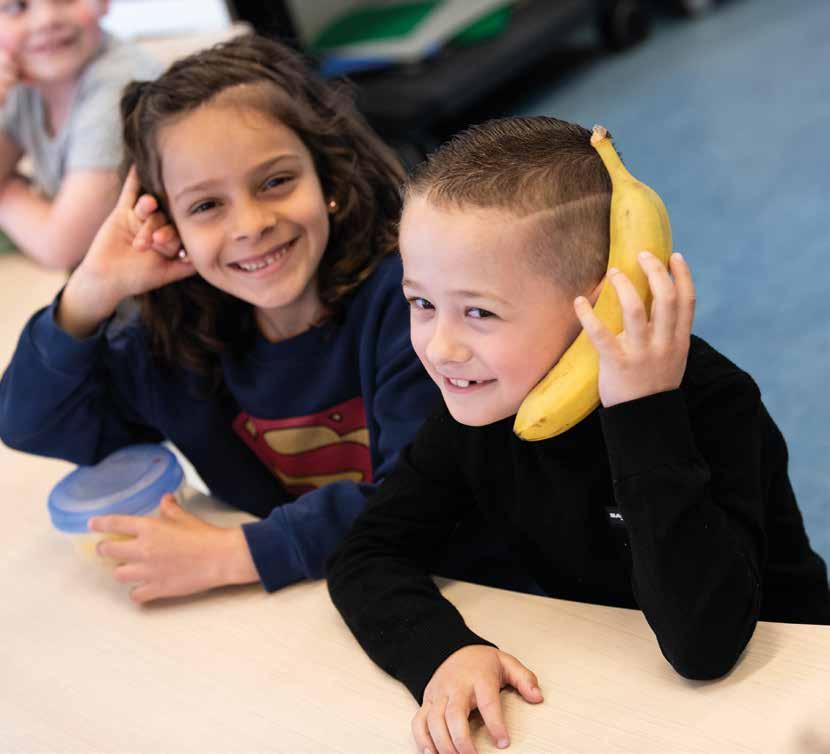 Gelukkige kinderen tijdens een les op KPO Basisschool De Watermolen in Roosendaal, met een jongen die een banaan als telefoon gebruikt. Gelukkige kinderen tijdens een les op KPO Basisschool De Watermolen in Roosendaal, met een jongen die een banaan als telefoon gebruikt.