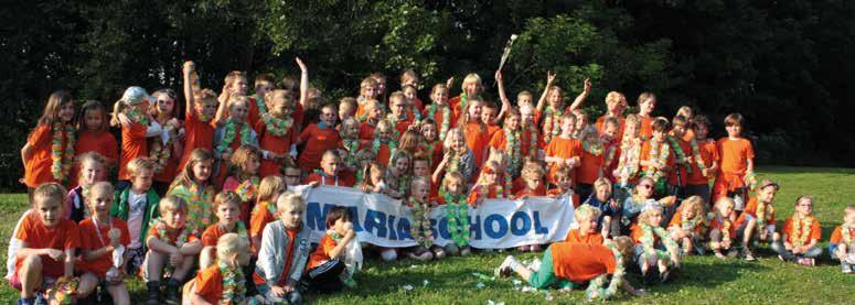 Groep blije kinderen in oranje shirts op het schoolplein van de Mariaschool in Hoorn. Groep blije kinderen in oranje shirts op het schoolplein van de Mariaschool in Hoorn.