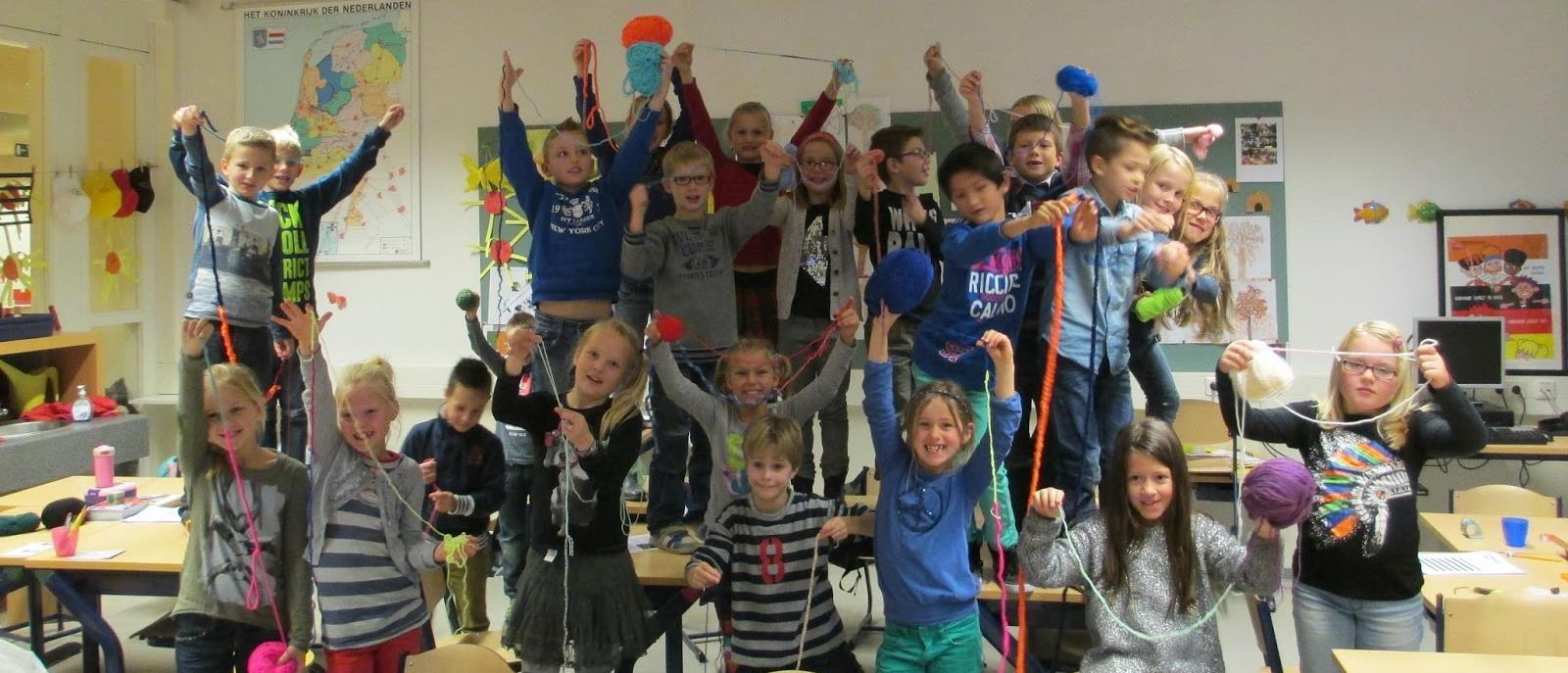 Groep blije kinderen met kleurrijke garen in de klas van De Wegwijzer in Elst (Gelderland). Groep blije kinderen met kleurrijke garen in de klas van De Wegwijzer in Elst (Gelderland).