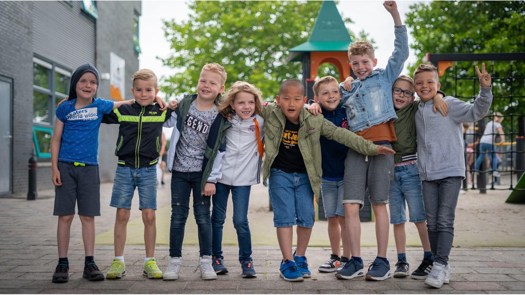Groep blije kinderen op het schoolplein van Oecumenische Daltonschool De Windwijzer in Almere. Groep blije kinderen op het schoolplein van Oecumenische Daltonschool De Windwijzer in Almere.
