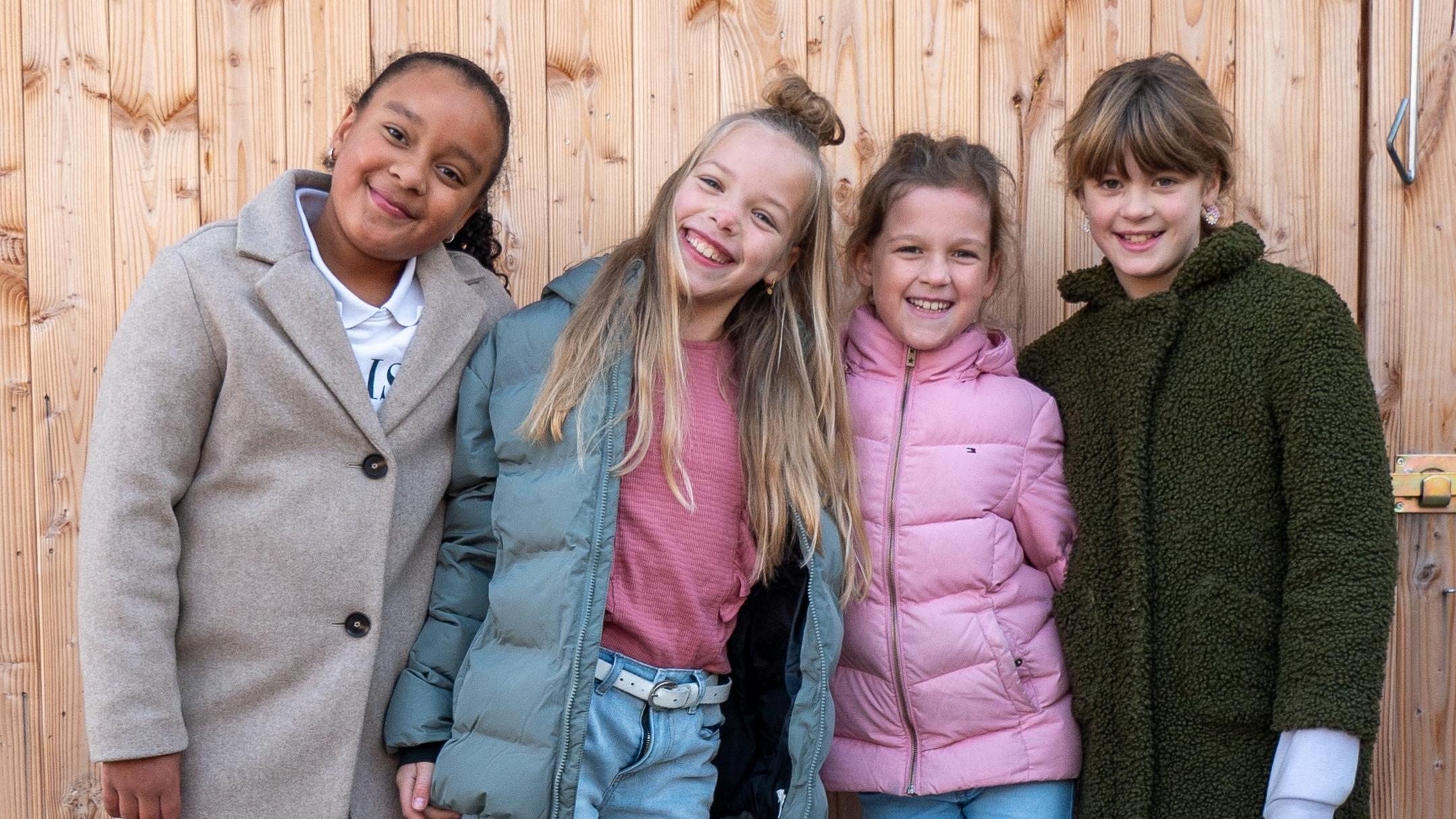 Groep blije kinderen poseert samen voor de houten achtergrond op het schoolplein van OBS De Octopus in Zwolle. Groep blije kinderen poseert samen voor de houten achtergrond op het schoolplein van OBS De Octopus in Zwolle.