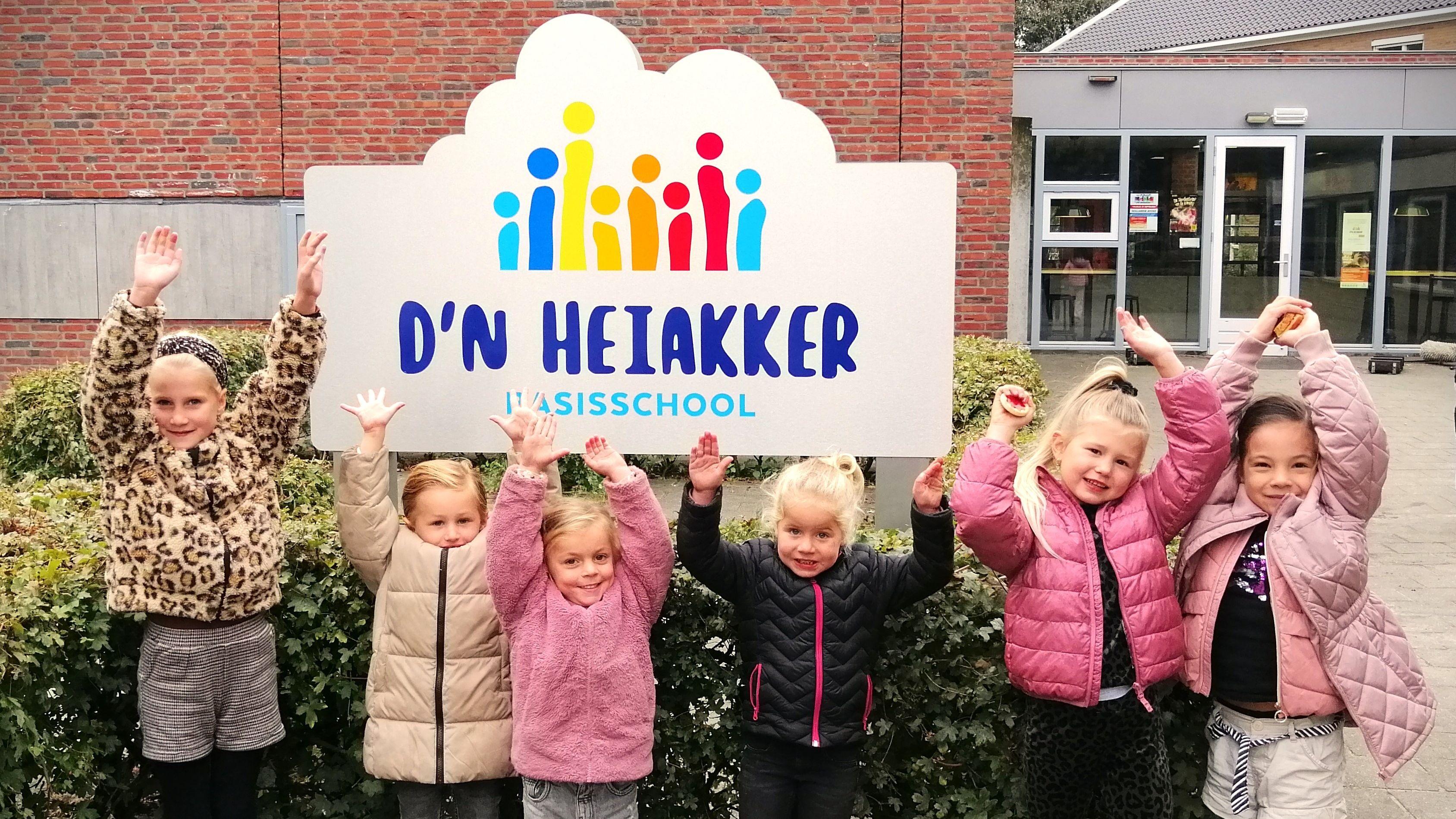 Groep blije kinderen poseren voor het bord van Basisschool d'n Heiakker in Deurne. Groep blije kinderen poseren voor het bord van Basisschool d'n Heiakker in Deurne.