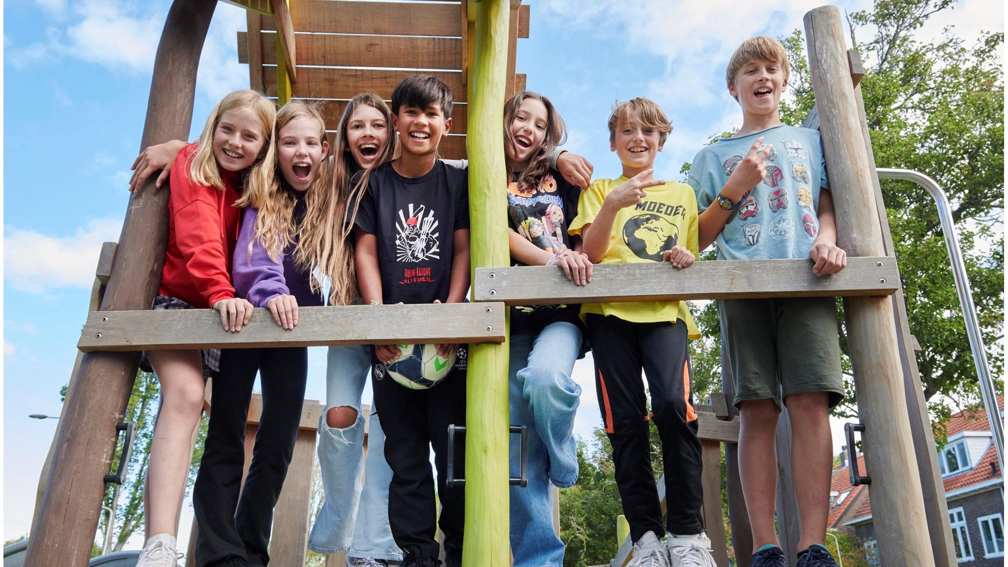 Groep blije kinderen speelt op het schoolplein van Openbare Basisschool De Wilgenhoek in Haarlem.