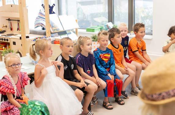 Groep enthousiaste kinderen in kostuums zittend in de klas van Christelijke Basisschool De Bron in Wezep.