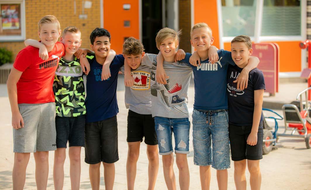 Groep kinderen poseert samen op het schoolplein van PCBO De Wonderboom in Amersfoort.