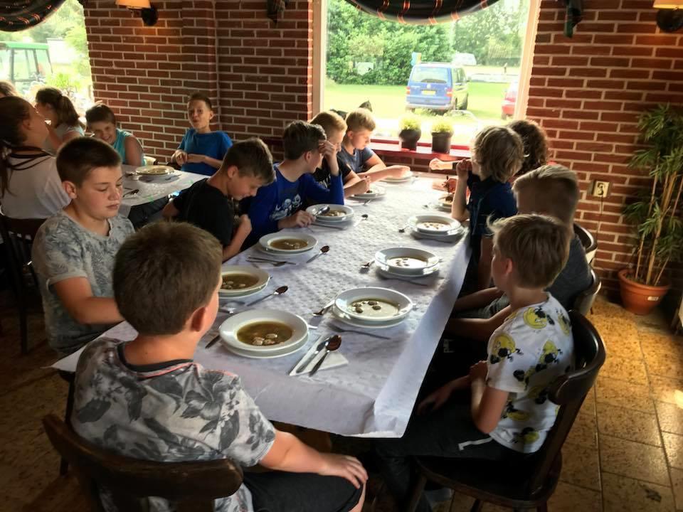 Groep kinderen van Dorpsschool Halle die samen soep eten tijdens een activiteit. Groep kinderen van Dorpsschool Halle die samen soep eten tijdens een activiteit.