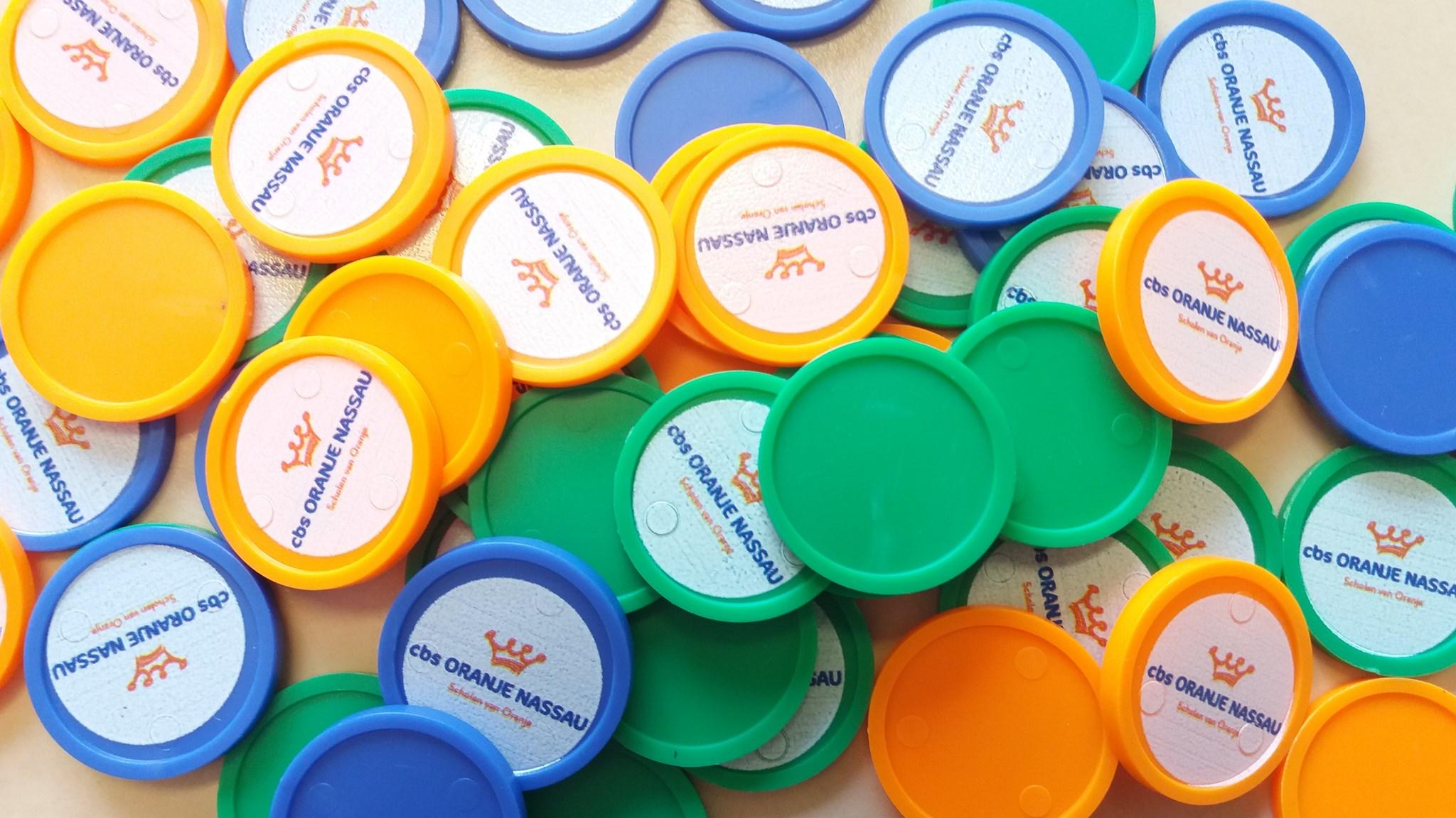 Groep kleurrijke speelmunten van cbs Oranje Nassauscholen in Dordrecht. Groep kleurrijke speelmunten van cbs Oranje Nassauscholen in Dordrecht.
