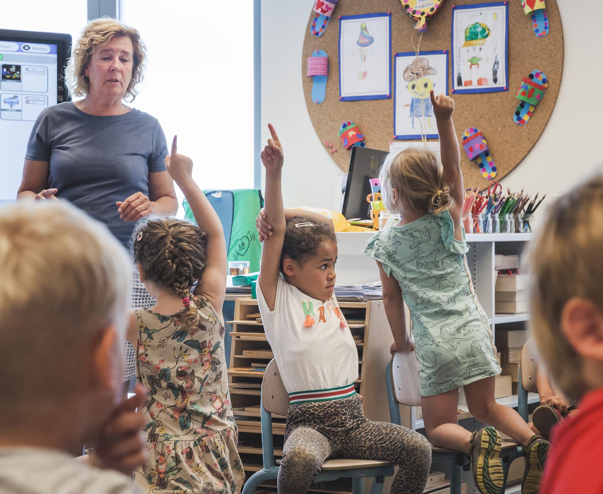 Groep leerlingen met opgeheven handen in de klas van Openbare Basisschool De Hasselbraam in Haaren. Groep leerlingen met opgeheven handen in de klas van Openbare Basisschool De Hasselbraam in Haaren.