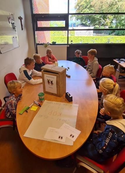 Groep leerlingen van de Rooms Katholieke Basisschool Sint Martinus in Voorst tijdens een vergadering rond een tafel. Groep leerlingen van de Rooms Katholieke Basisschool Sint Martinus in Voorst tijdens een vergadering rond een tafel.
