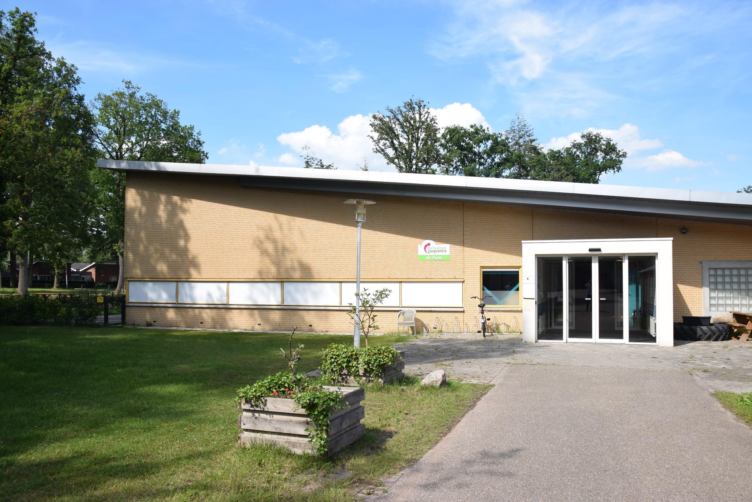 Het gebouw van basisschool De Meander in Losser met een groen schoolplein.