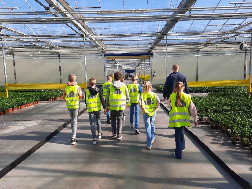 Het onderwerp toont leerlingen van Christelijke Basisschool De Wiekslag uit Bleiswijk die met veiligheidshesjes door een kas lopen.
