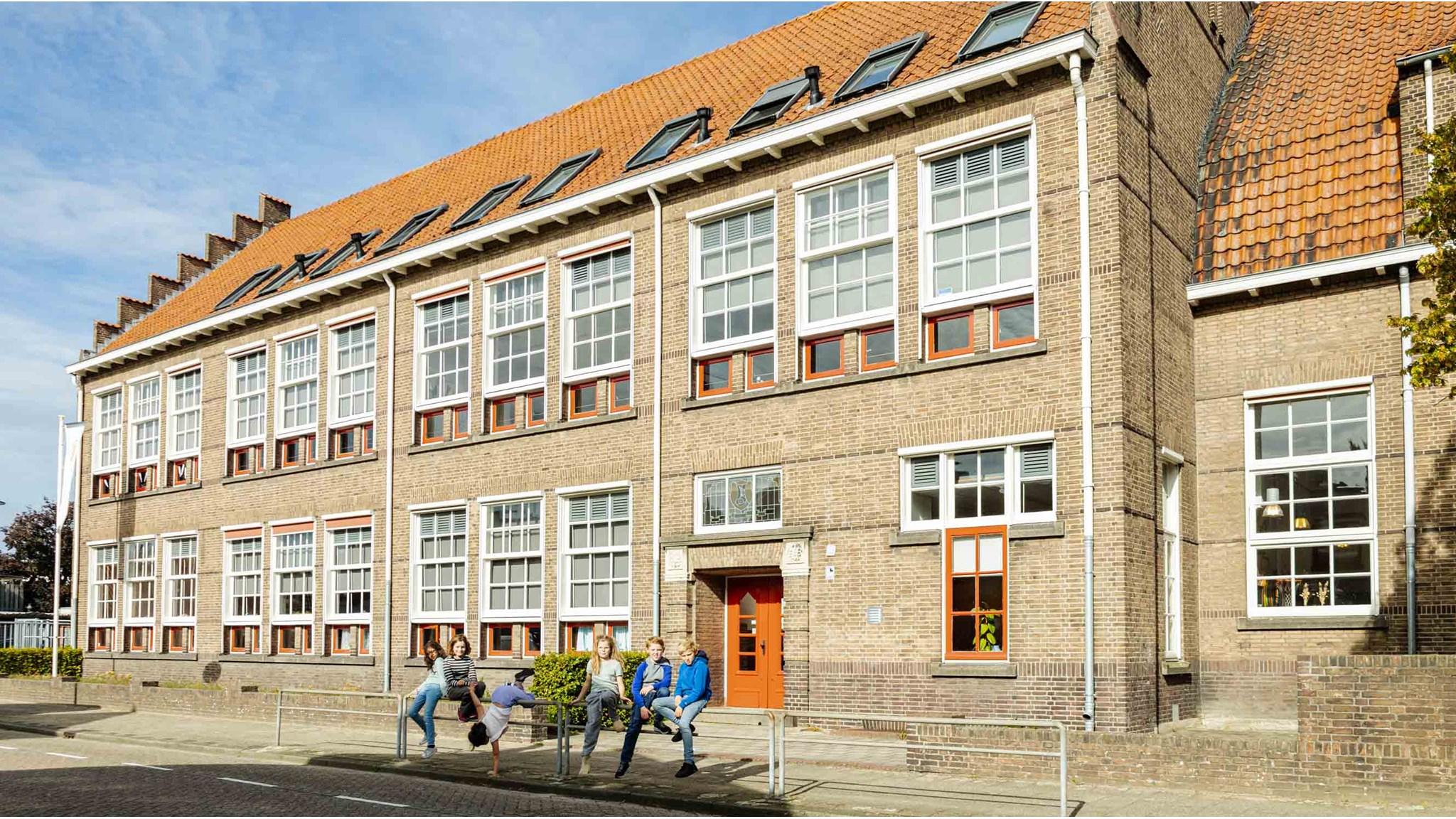 Het schoolgebouw van IKC Sint Jan in Hengelo met kinderen die op het schoolplein spelen. Het schoolgebouw van IKC Sint Jan in Hengelo met kinderen die op het schoolplein spelen.