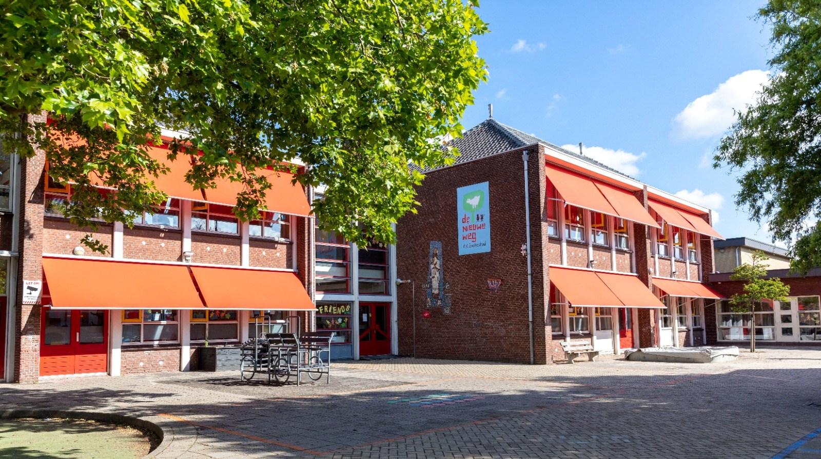 Het schoolgebouw van WSKO Basisschool De Nieuwe Weg in Poeldijk met een helderblauwe lucht en groen omhulsel. Het schoolgebouw van WSKO Basisschool De Nieuwe Weg in Poeldijk met een helderblauwe lucht en groen omhulsel.
