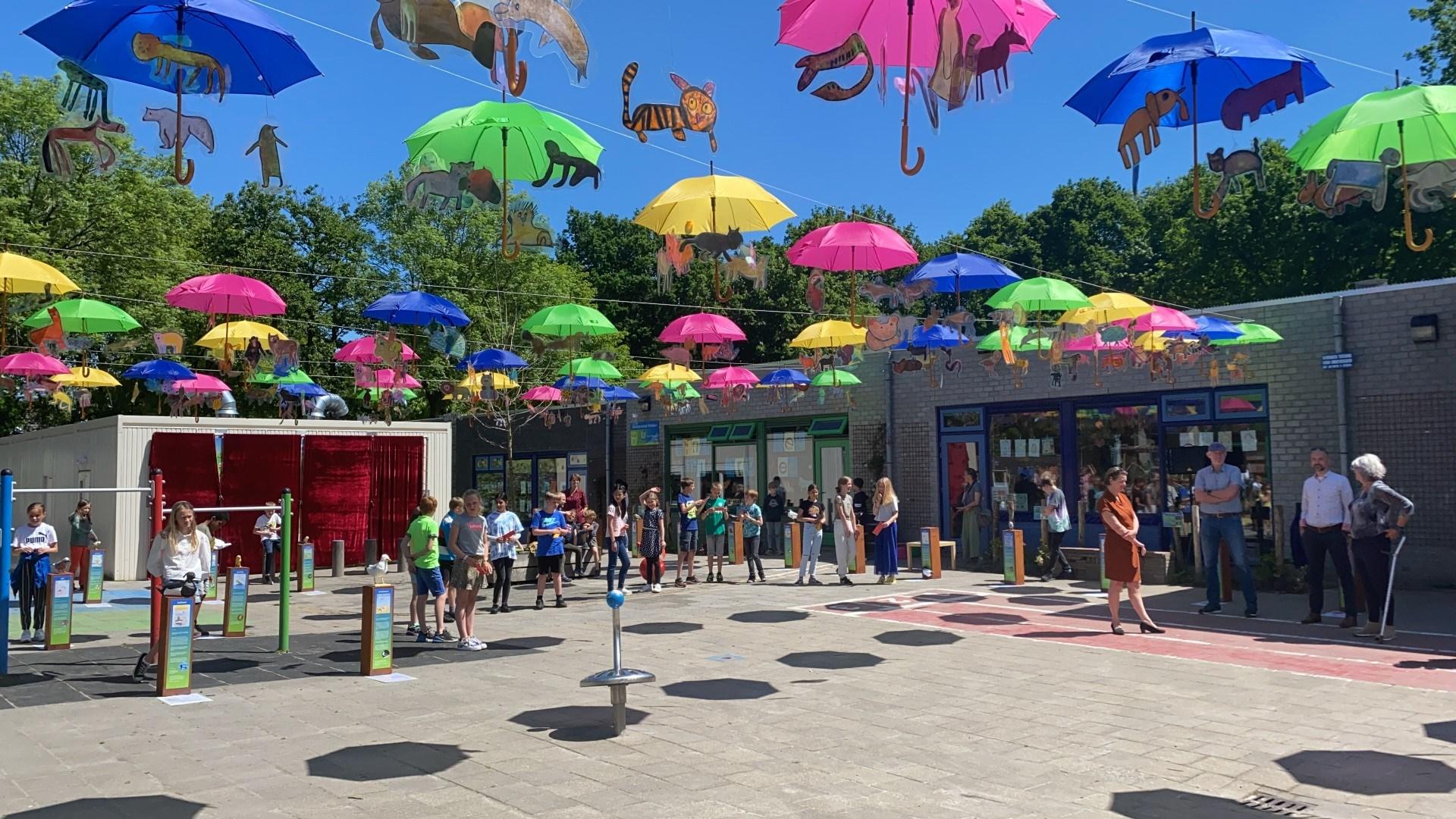 Het schoolplein van de Bredero-School in Groningen, versierd met kleurrijke parasols en kinderen die spelen. Het schoolplein van de Bredero-School in Groningen, versierd met kleurrijke parasols en kinderen die spelen.