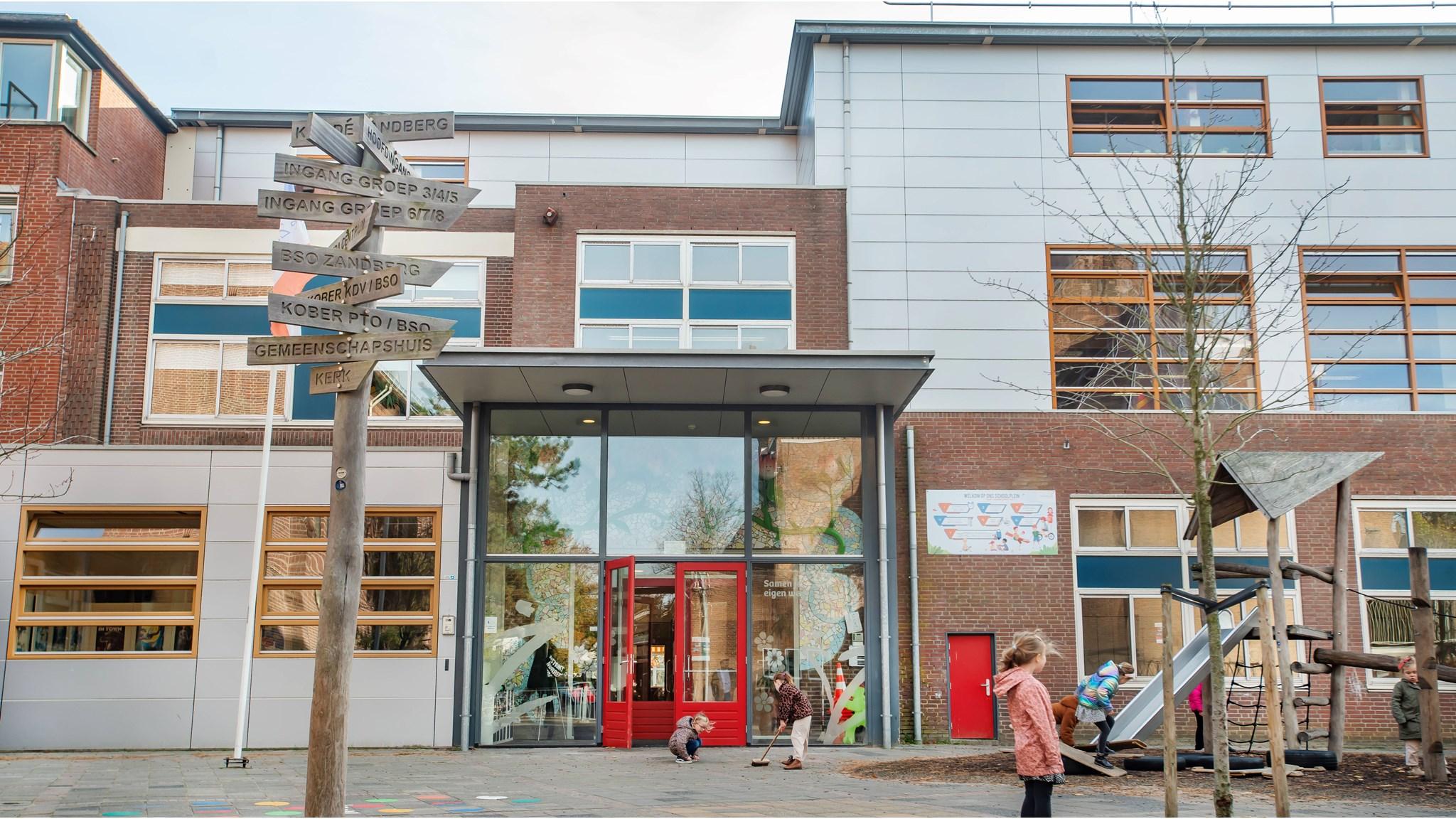 Het schoolplein van De Zandberg in Breda met een overzicht van ingangen en kinderen die spelen. Het schoolplein van De Zandberg in Breda met een overzicht van ingangen en kinderen die spelen.