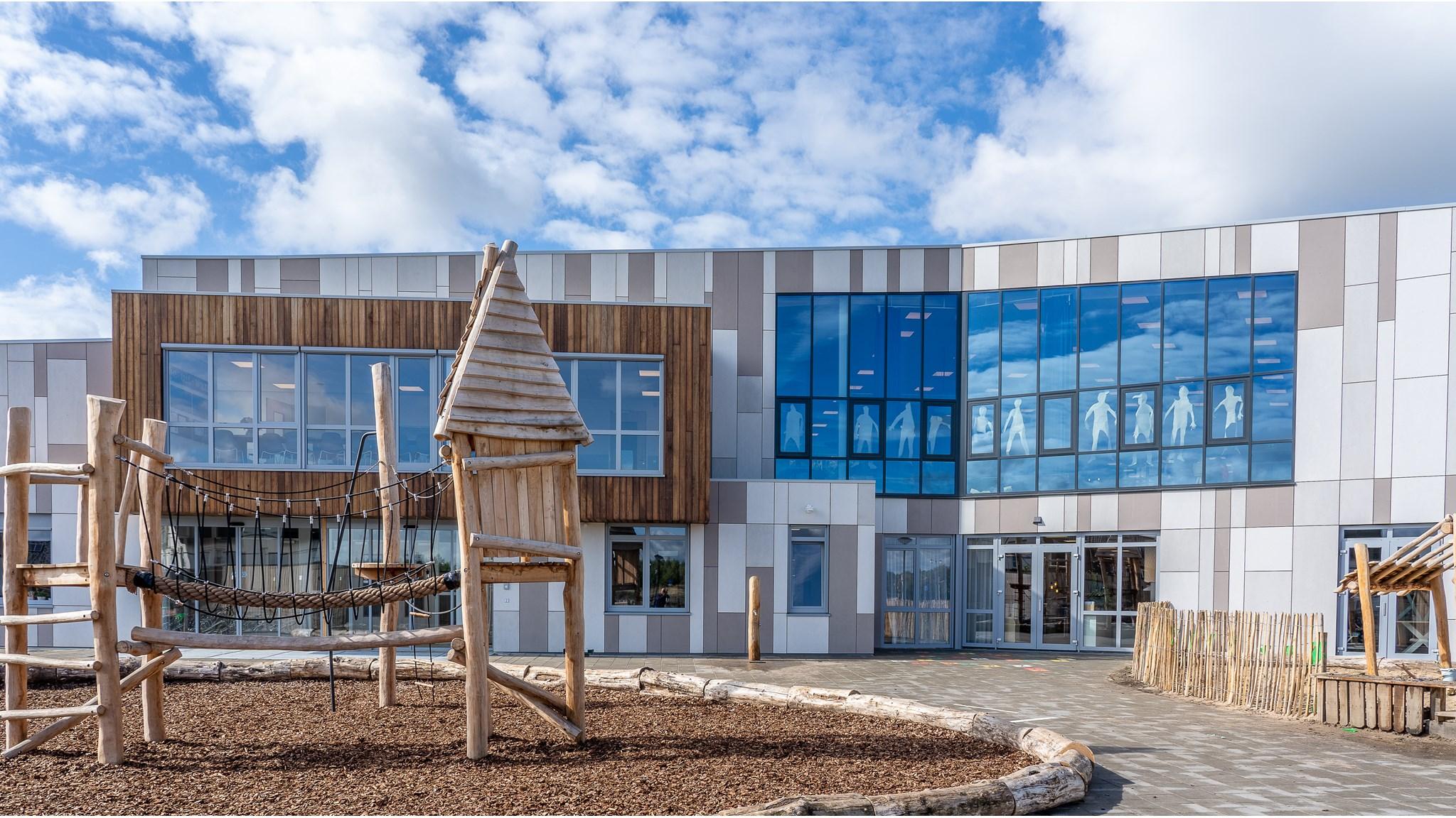 Het schoolplein van Kindcentrum De Uitdaging in Nijmegen met speeltoestellen en moderne gebouwen. Het schoolplein van Kindcentrum De Uitdaging in Nijmegen met speeltoestellen en moderne gebouwen.