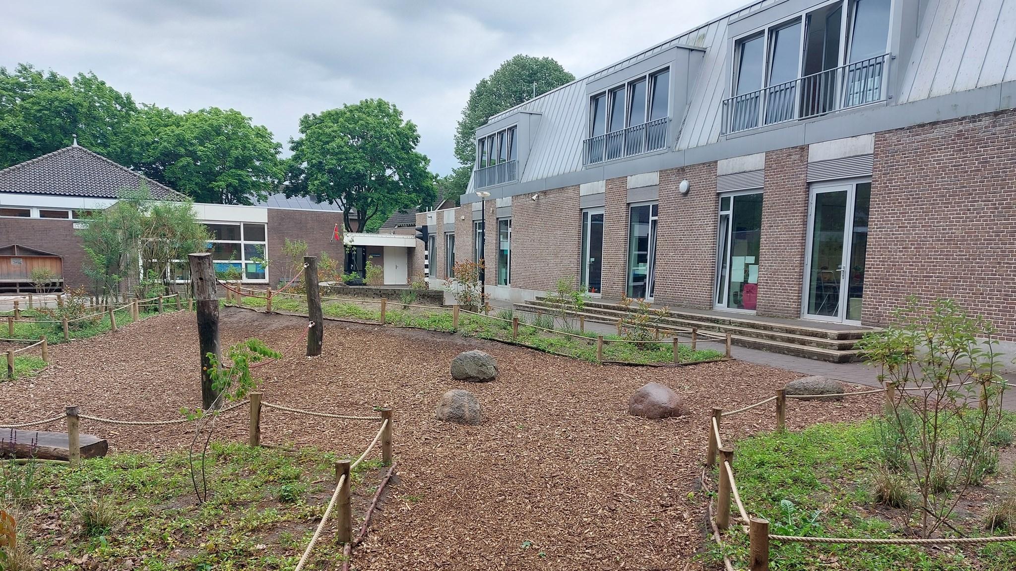 Het schoolplein van KOC De Brakken in Rijen met natuurlijke elementen en groen. Het schoolplein van KOC De Brakken in Rijen met natuurlijke elementen en groen.