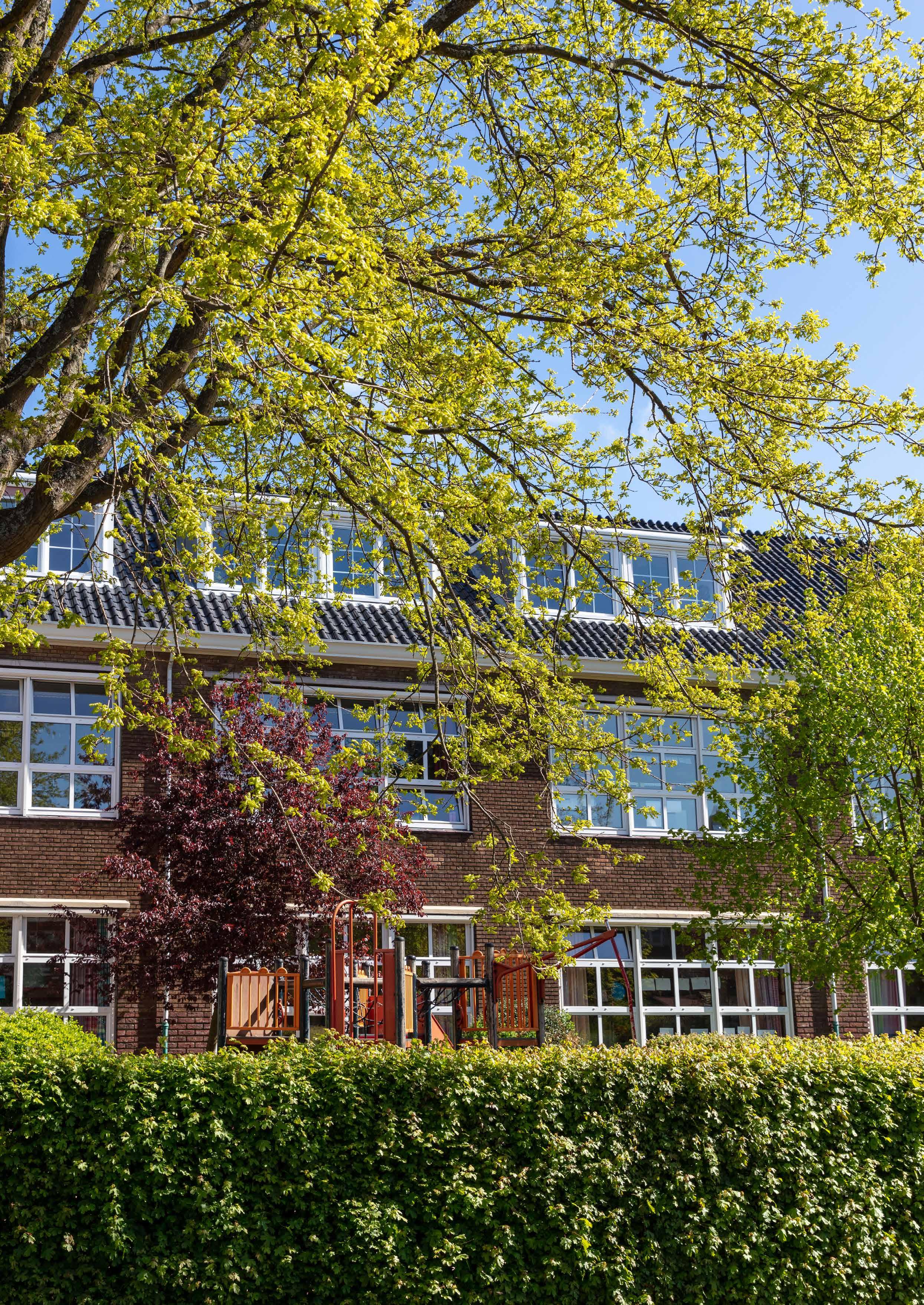 Het schoolplein van Openbare Basisschool Bornwaterschool in Bloemendaal met een groene omgeving en speeltoestellen. Het schoolplein van Openbare Basisschool Bornwaterschool in Bloemendaal met een groene omgeving en speeltoestellen.