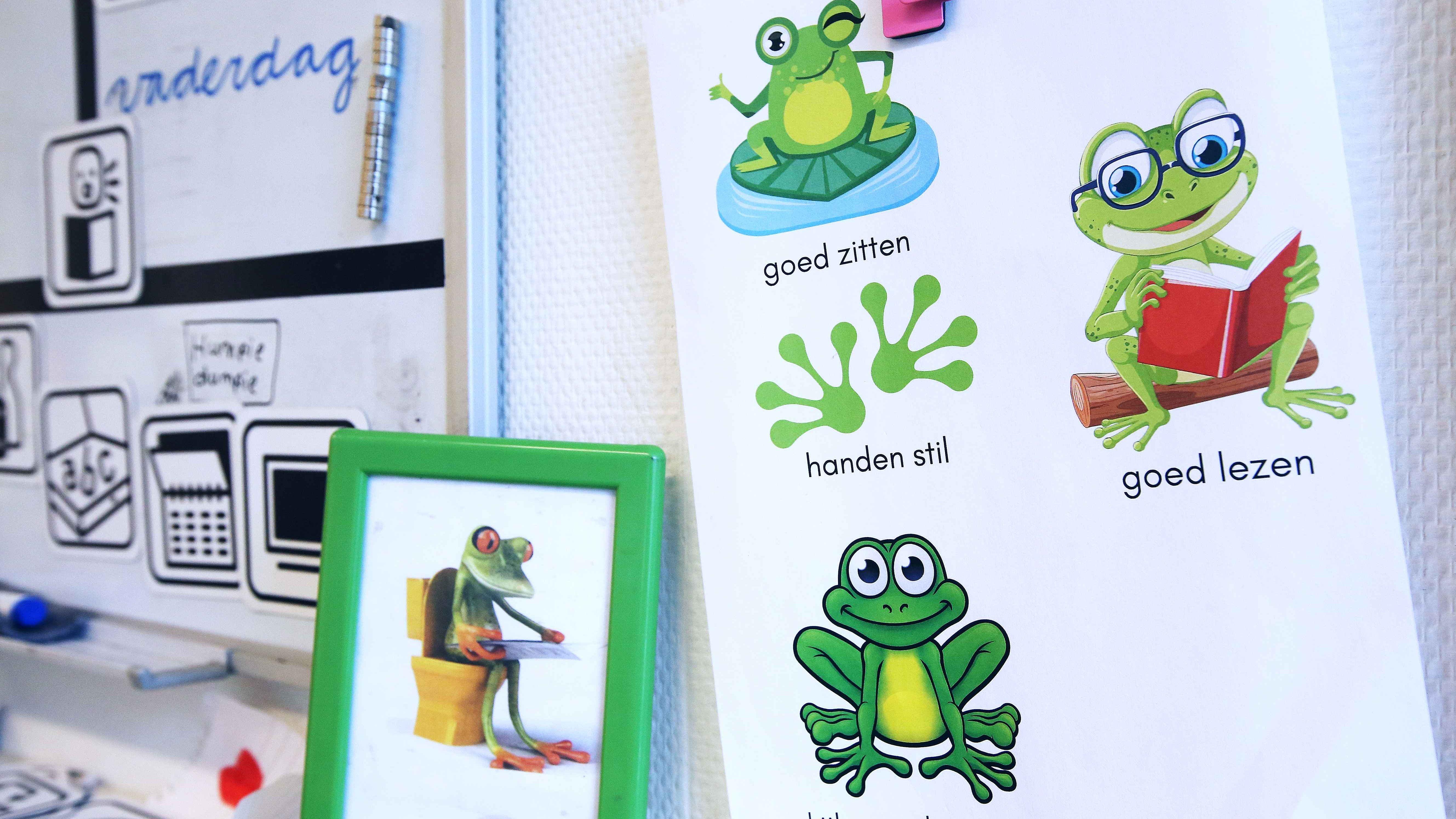 In de klas van Basisschool De Springplank in Etten-Leur staan afbeeldingen van kikkers met instructies voor goed zitten, handen stil en goed lezen. In de klas van Basisschool De Springplank in Etten-Leur staan afbeeldingen van kikkers met instructies voor goed zitten, handen stil en goed lezen.