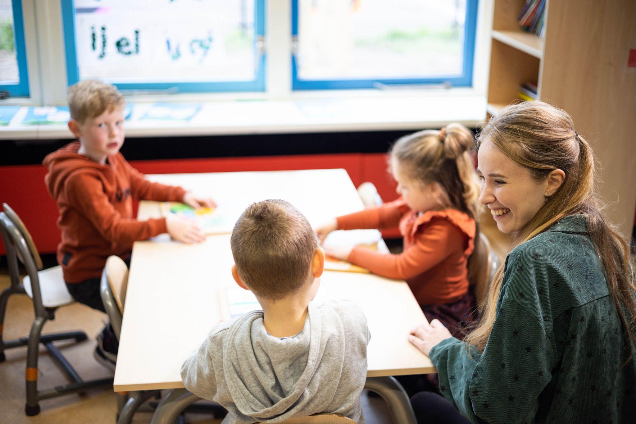 In de klas van CBS De Klimop in Ridderkerk werken leerlingen samen met een lerares aan een activiteit. In de klas van CBS De Klimop in Ridderkerk werken leerlingen samen met een lerares aan een activiteit.