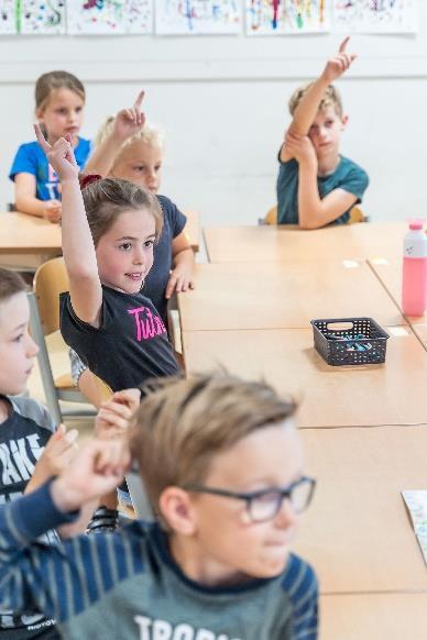 In de klas van Openbare Basisschool De Trumakkers in Heeze steken kinderen hun handen op om deel te nemen aan de les. In de klas van Openbare Basisschool De Trumakkers in Heeze steken kinderen hun handen op om deel te nemen aan de les.