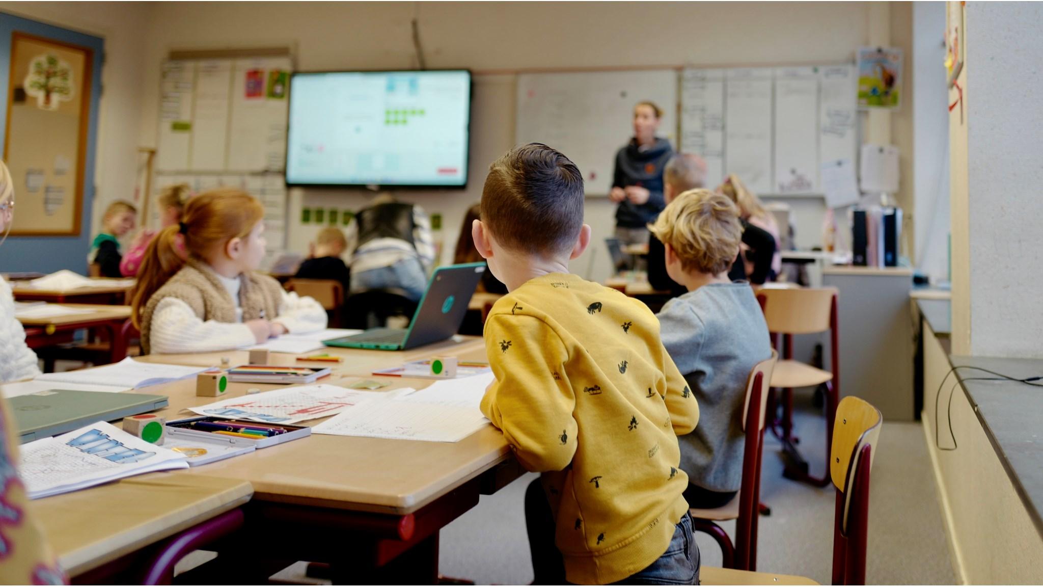 In een klaslokaal van Openbare Basisschool Klim-op in Hoornaar zitten leerlingen aandachtig te luisteren naar de lerares die uitleg geeft. In een klaslokaal van Openbare Basisschool Klim-op in Hoornaar zitten leerlingen aandachtig te luisteren naar de lerares die uitleg geeft.