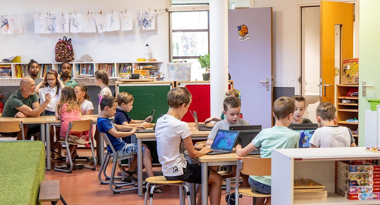 In het klaslokaal van Kindplein 't Centrum in Uden zijn kinderen aan het werk met laptops terwijl ze samen leren. In het klaslokaal van Kindplein 't Centrum in Uden zijn kinderen aan het werk met laptops terwijl ze samen leren.