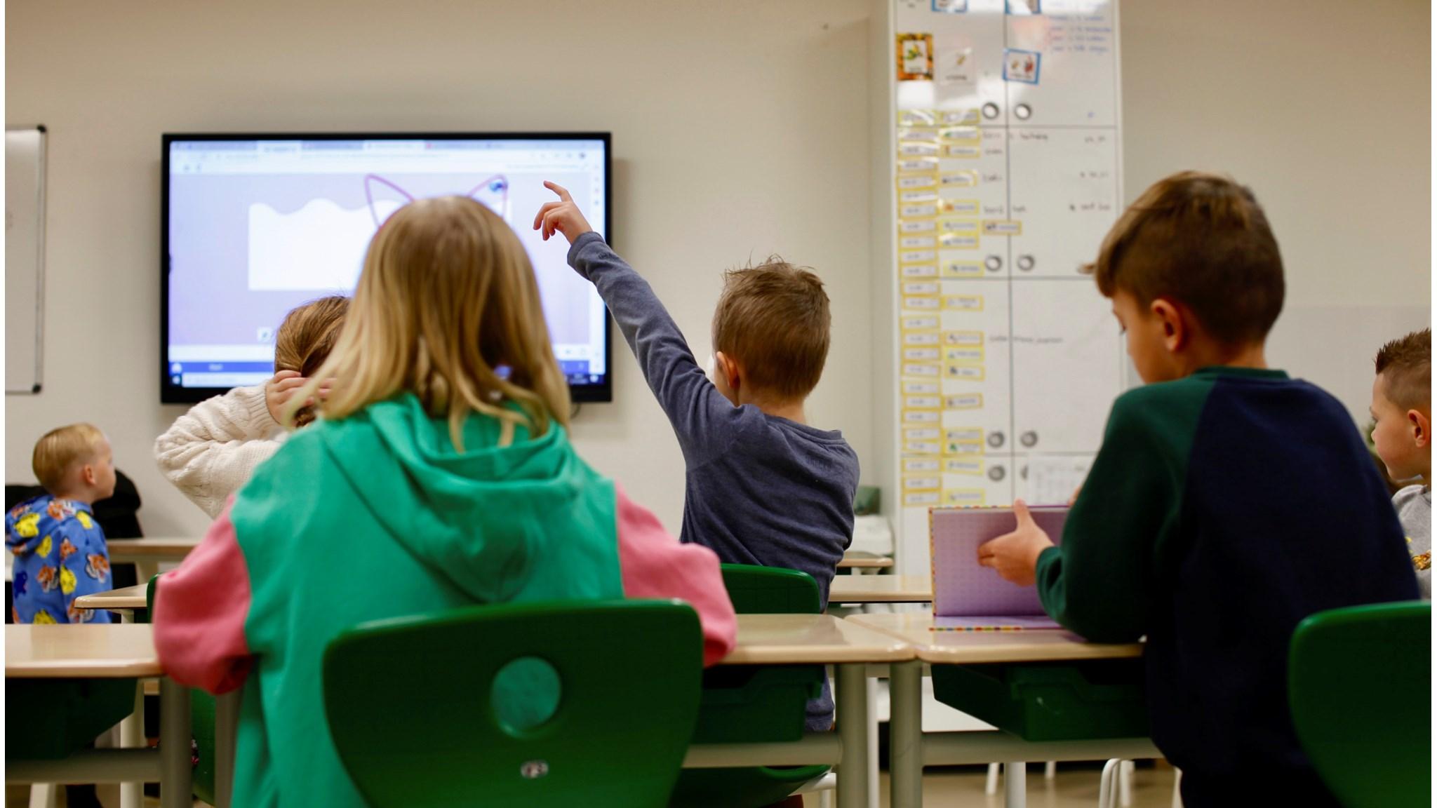 In het klaslokaal van OBS 'Het Tweespan', locatie Schelluinen, zijn kinderen actief bezig met de les terwijl één leerling zijn hand opsteekt. In het klaslokaal van OBS 'Het Tweespan', locatie Schelluinen, zijn kinderen actief bezig met de les terwijl één leerling zijn hand opsteekt.
