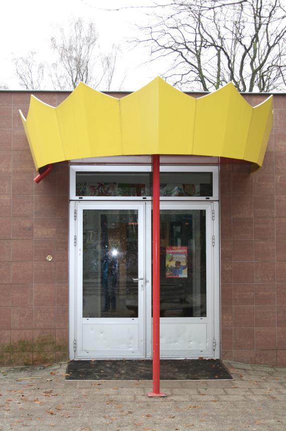 Ingang van de Koning Davidschool in Ede, voorzien van een opvallende gele kroon. Ingang van de Koning Davidschool in Ede, voorzien van een opvallende gele kroon.