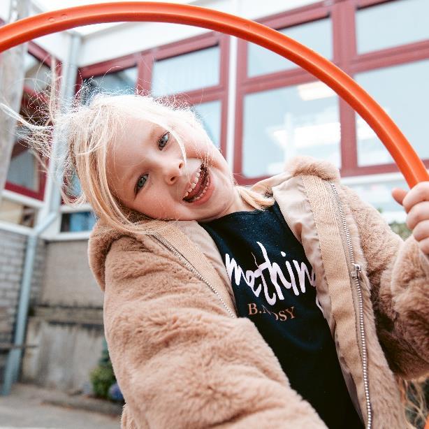Kind speelt vrolijk met een hoepel op het schoolplein van de Bernardusschool in Den Haag. Kind speelt vrolijk met een hoepel op het schoolplein van de Bernardusschool in Den Haag.