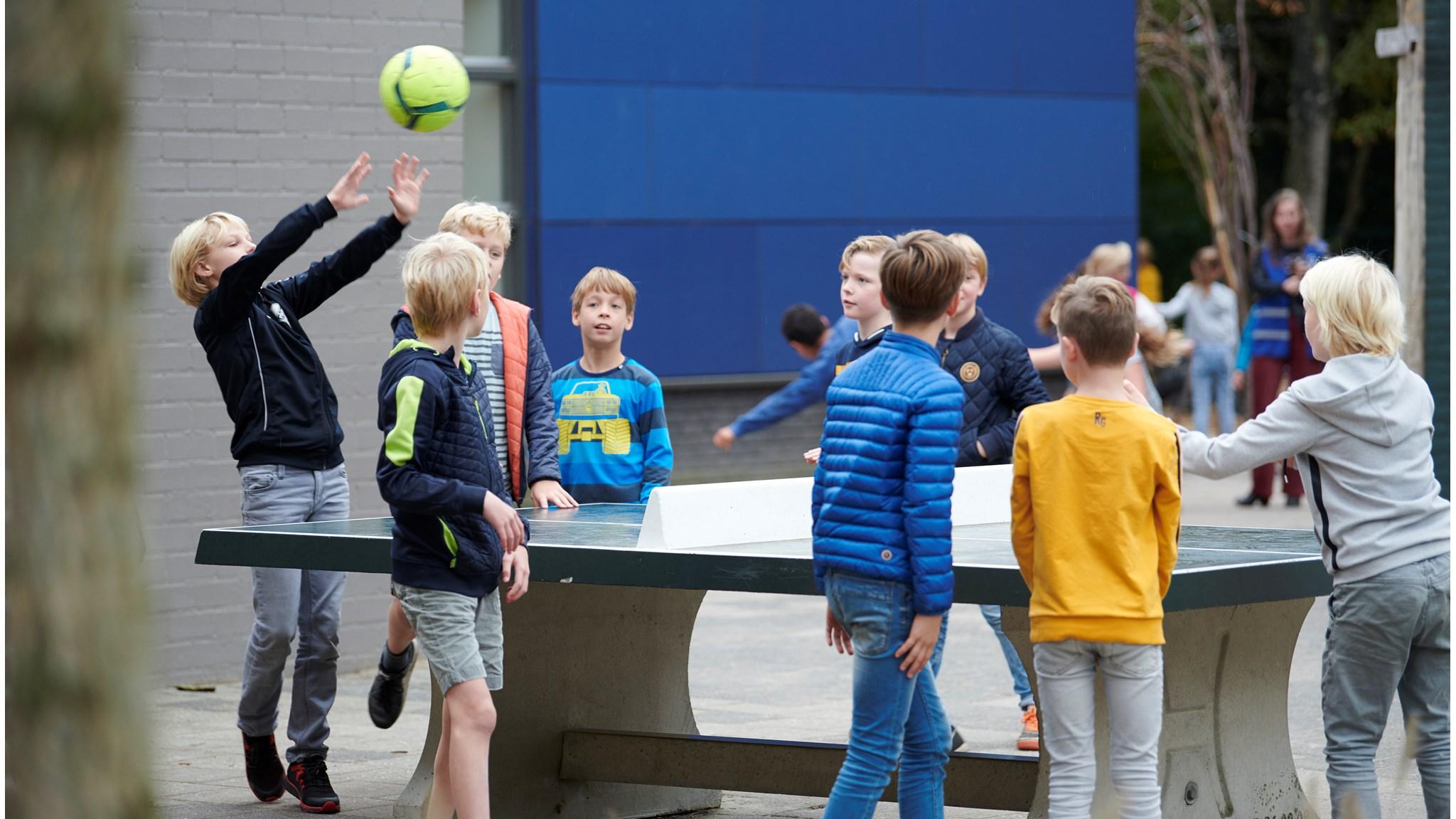 Kindcentrum Christoffel in Tilburg: Kinderen spelen op het schoolplein met een tafeltennistafel en een bal. Kindcentrum Christoffel in Tilburg: Kinderen spelen op het schoolplein met een tafeltennistafel en een bal.