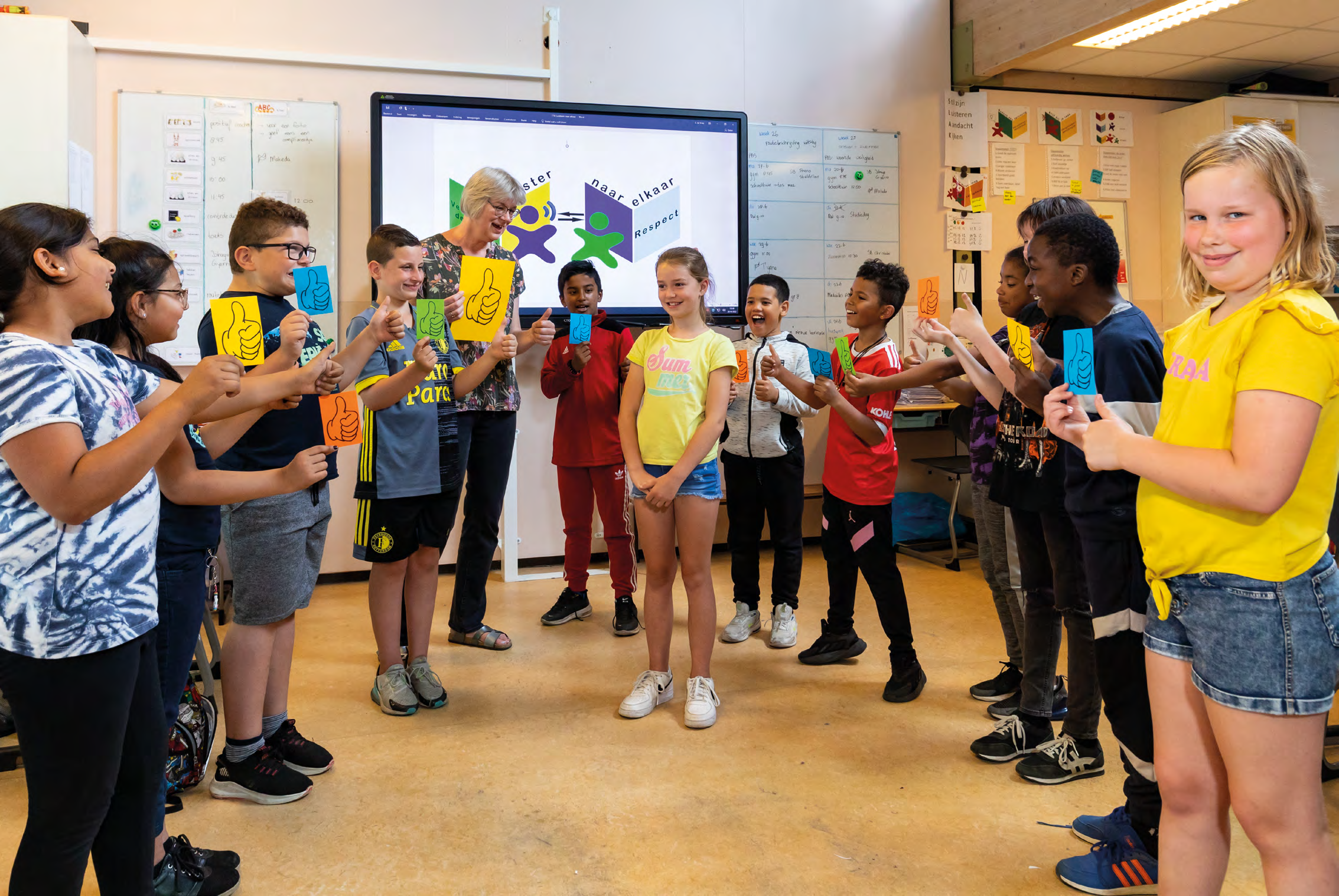 Kindcentrum De Buskes in Rotterdam, leerlingen participeren in een interactieve activiteit met kleurgecodeerde duim omhoog kaarten. Kindcentrum De Buskes in Rotterdam, leerlingen participeren in een interactieve activiteit met kleurgecodeerde duim omhoog kaarten.