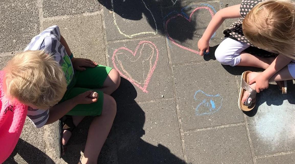 Kindcentrum de Diedeldoorn in Emmen, kinderen tekenen met krijt op het schoolplein. Kindcentrum de Diedeldoorn in Emmen, kinderen tekenen met krijt op het schoolplein.