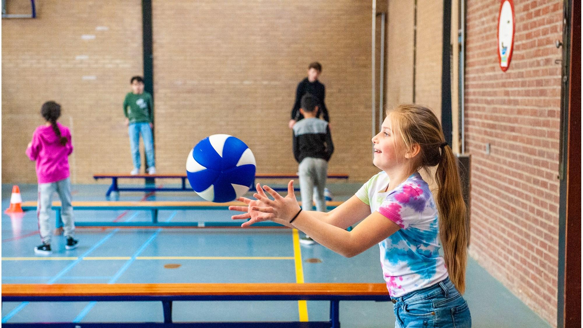 Kindcentrum De Heijberg in Rotterdam biedt een actieve gymles waarin leerlingen plezier hebben met een bal.