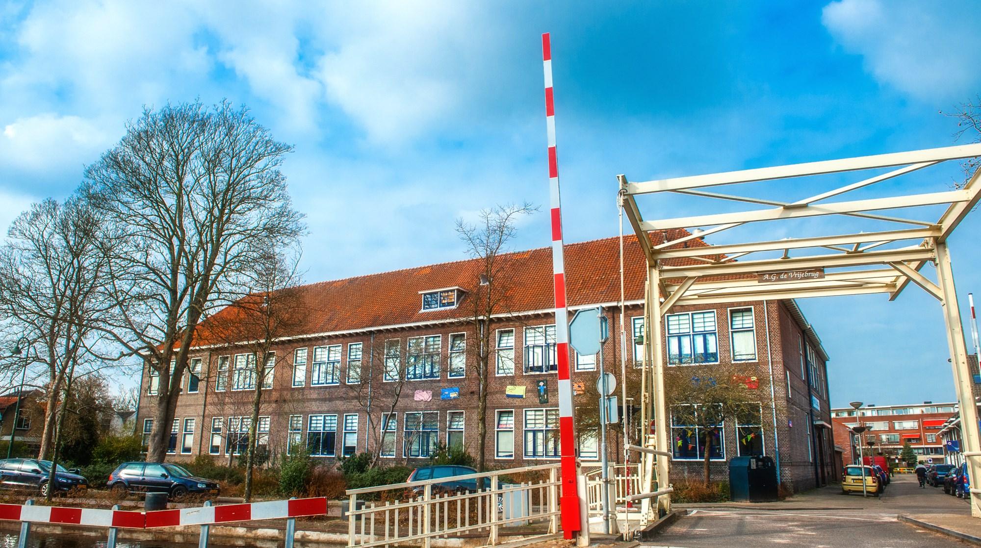 Kindcentrum De Heijberg in Rotterdam, met een zicht op het schoolgebouw en de toegangspoort.