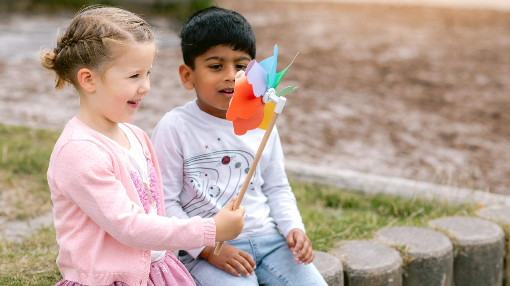 Kindcentrum De Helmstok in Lelystad, kinderen spelen met een kleurrijke wimpel op het schoolplein. Kindcentrum De Helmstok in Lelystad, kinderen spelen met een kleurrijke wimpel op het schoolplein.