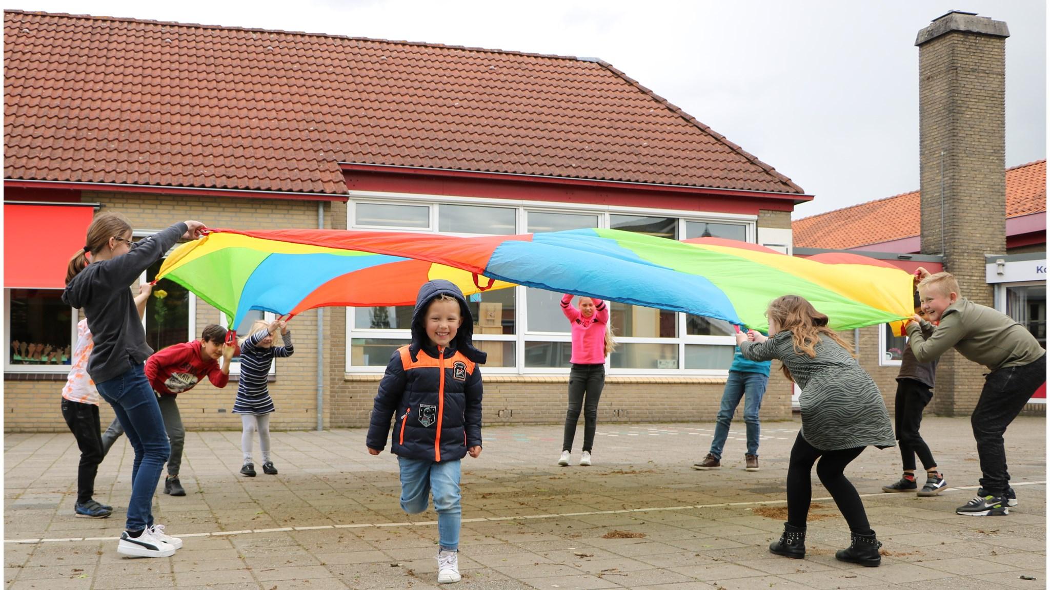 Kindcentrum De Koningsberger in Bergentheim waar kinderen spelenderwijs met een parachute spelen op het schoolplein. Kindcentrum De Koningsberger in Bergentheim waar kinderen spelenderwijs met een parachute spelen op het schoolplein.