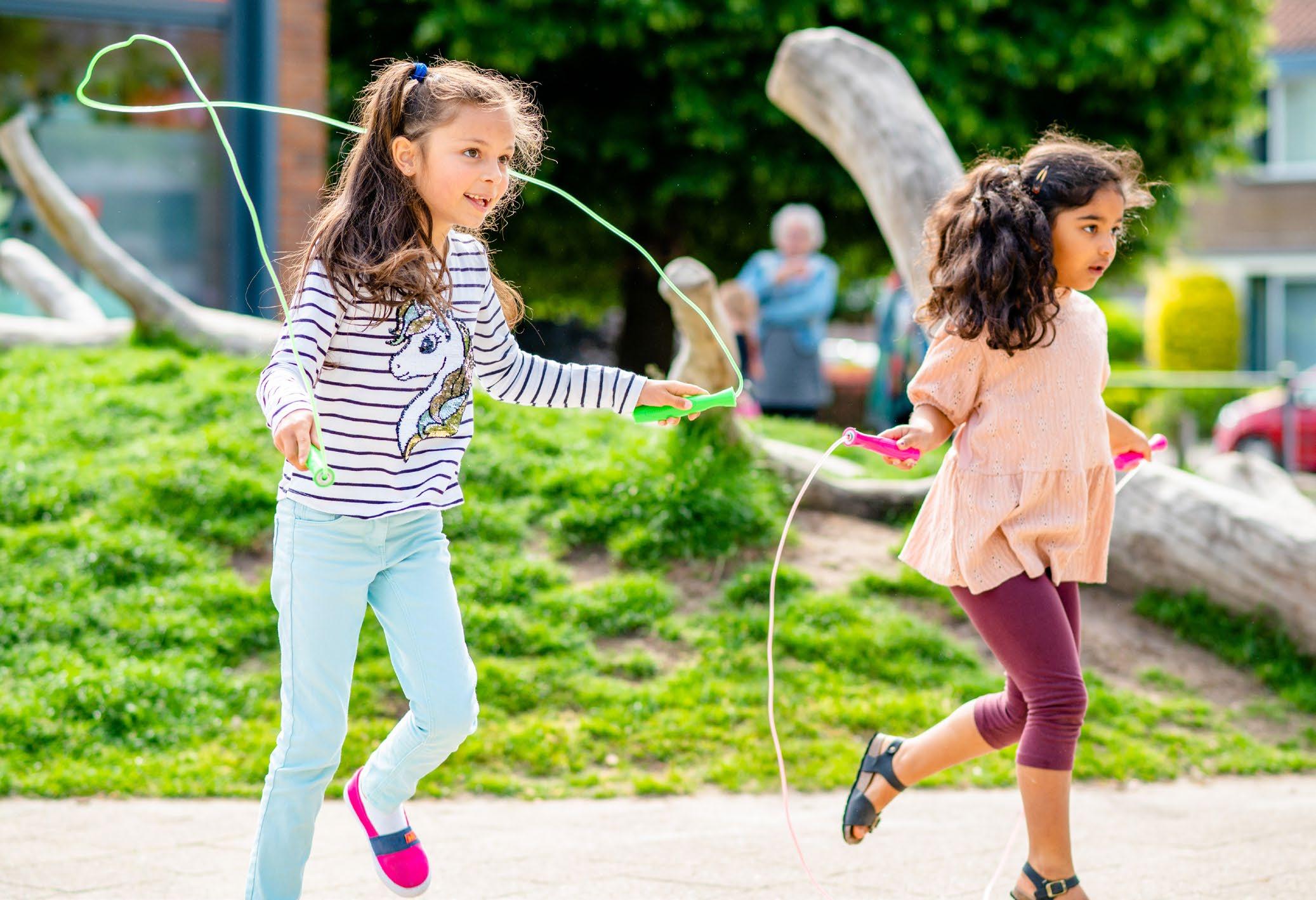 Kindcentrum De Morgenster in Zwolle: kinderen spelen en springen touwtjespringend op het schoolplein.