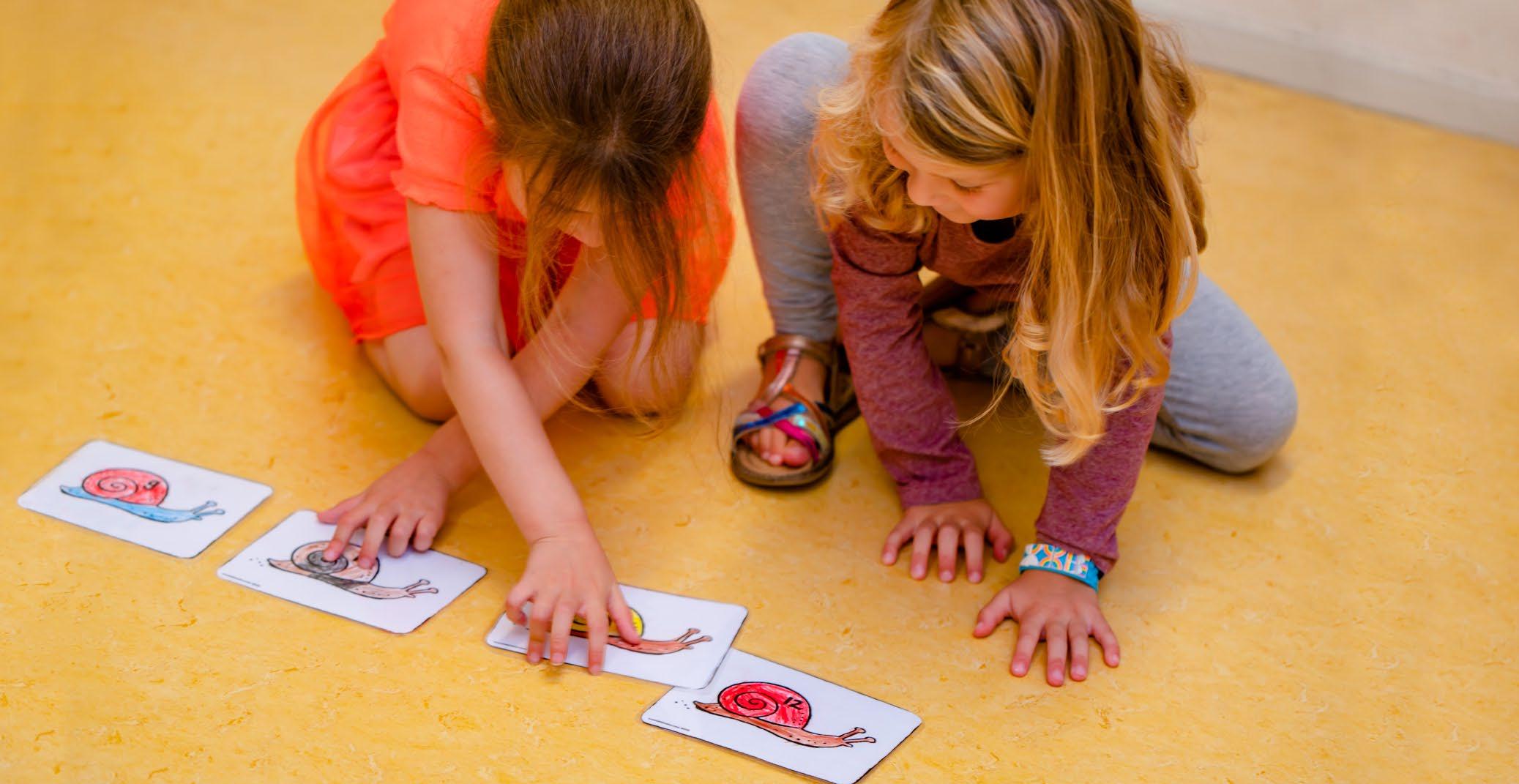 Kindcentrum De Morgenster in Zwolle, twee kinderen spelen met afbeeldingen van slakken op de vloer.